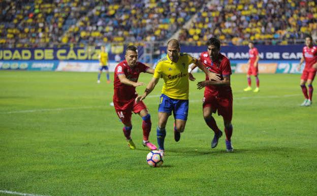 Ortuño, perseguido por dos rivales, en un encuentro con el Cádiz.