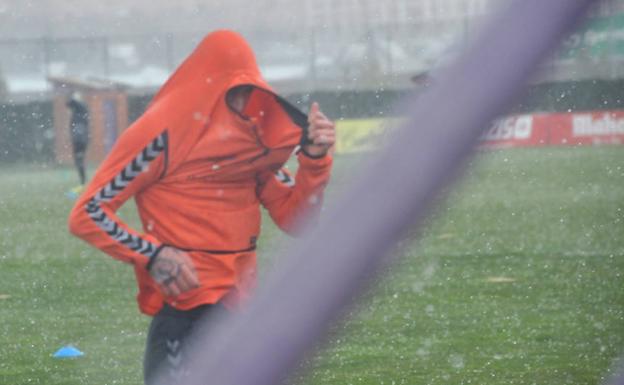 Calero intenta taparse la cabeza durante la fuerte granizada que cayó sobre los Anexos./Rodrigo Jiménez