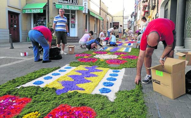 Vecinos de Carrión de los Condes preparan la alfombra floral para que pase la procesión.