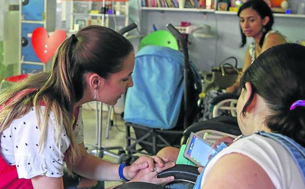 Una voluntaria de Pyfano en el hospital de día de la planta de Pediatría del Complejo Asistencial.