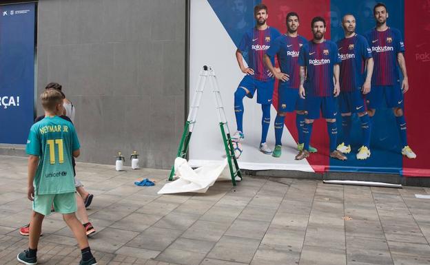 Un niño con la camiseta de Neymar contempla un póster en el exterior del Camp Nou en el que ya no hay rastro del brasileño. /Josep Lago (Afp)