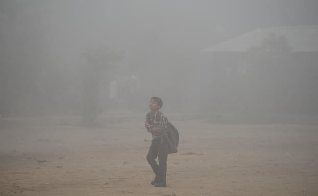 Un niño, yendo a la escuela en Nueva Delhi./AFP