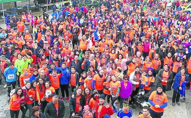 Participantes en la marcha posan con las camisetas de color naranja. /C. Vega