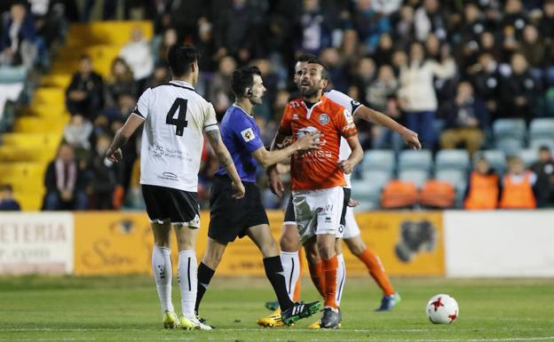 Chuchi, a la derecha sujetado por el árbitro, durante el derbi ante el Salmantino. /MANUEL LAYA