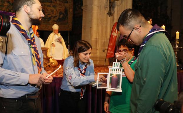 La presidenta de los scouts de Palencia, Judith González, enciende velas, durante la ceremonia, presidida por el obispo. /Marta Moras