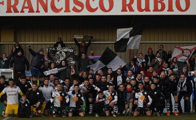 Los jugadores y cuerpo técnico de Unionistas celebran con su afición desplazada a Soria el triunfo ante el CD Numancia. /USCF