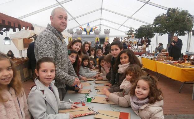 Participantes en el taller de pulseras dentro de la carpa./Cristina Vega