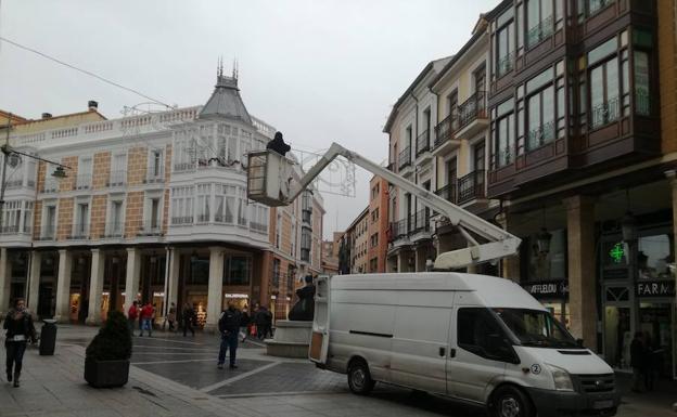 Los operarios retiran los arcos de luz esta mañana./J. Olano
