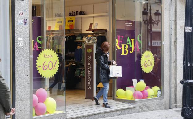 Una mujer sale de un establecimiento comercial del centro de la ciudad./MANUEL LAYA