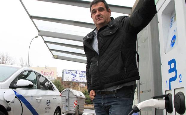 Fernando Núñez, presidente de los taxistas, con su vehículo en el punto de recarga de la estación de autobuses. /Antonio Tanarro