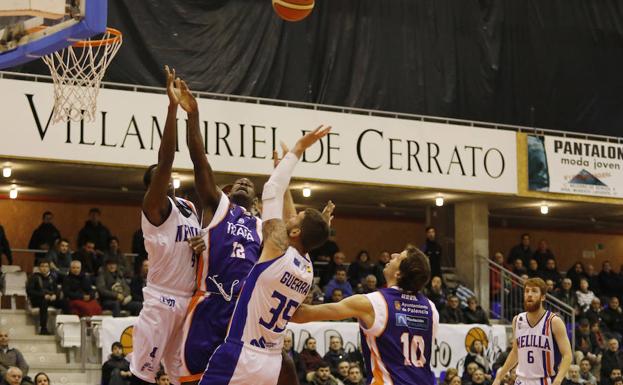 Ruffin pelea un rebote bajo el aro ante dos rivales del Melilla./MARTA MORAS