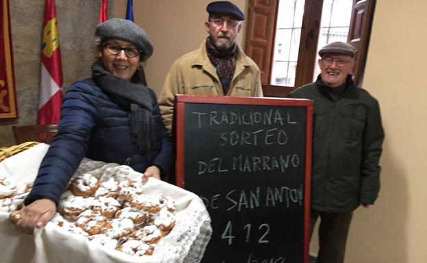 La alcaldesa con las rosquillas que se repartieron tras el sorteo y dos ediles muestran el número premiado./WORD