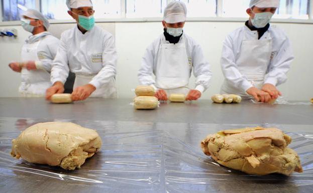 Varios trabajadores, preparan lotes de paté./