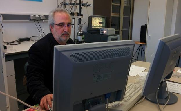 [El catedrático Pedro Prádanos observa en la pantalla una muestra a través de un microscopio de fuerza atómica (a sus espaldas). /UVA