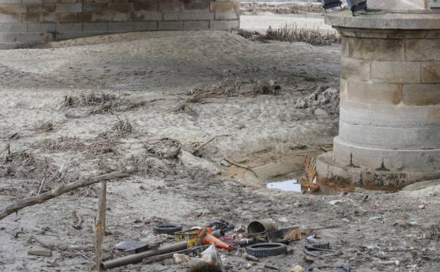Basura en el lecho del río junto al puente Enrique Estevan. /LAYA