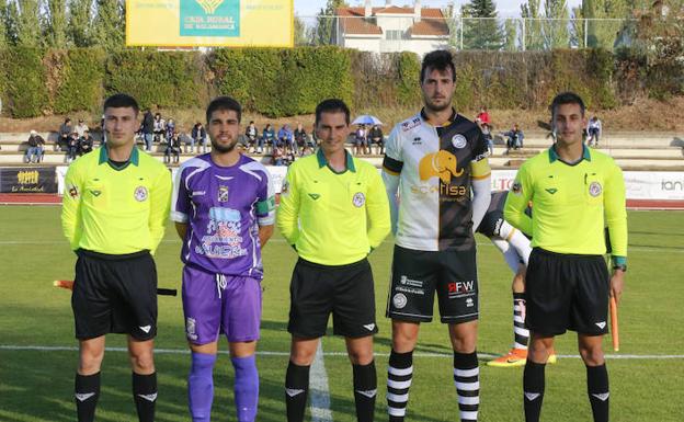 Los capitanes de Unionistas y Becerril posan con el trío arbitral en el partido en Las Pistas. /MANUEL LAYA