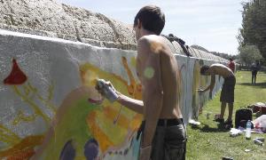 Varios de los participantes al concurso de grafitis pintan el miércoles, un muro en el parque de la Carcavilla./