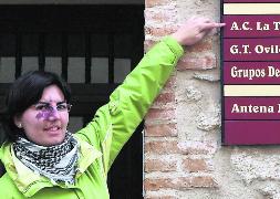 María Eugenia González señala el cartel de la sede la asociación. / C. Catalina/