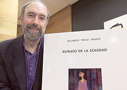 Eduardo Fraile, ante el cartel de la portada de su libro con el cuadro de Julio Toquero. / H. SASTRE/