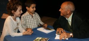 Isaías Rodrigo conversa con dos niños mientras les firma el libro recién presentado. ::
M. RICO/