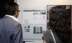 Dos visitantes de la exposición observan el trabajo ganador en la categoría de vivienda colectiva. ::
A. Q/