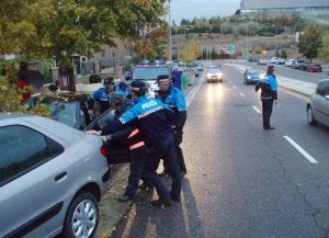Los policías locales retiran el Seat León de la calzada. :: J. S./