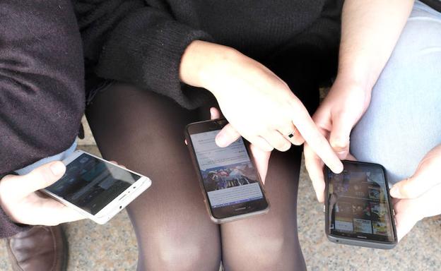 Varios adolescentes, con sus telÃ©fonos mÃ³viles. /RamÃ³n GÃ³mez